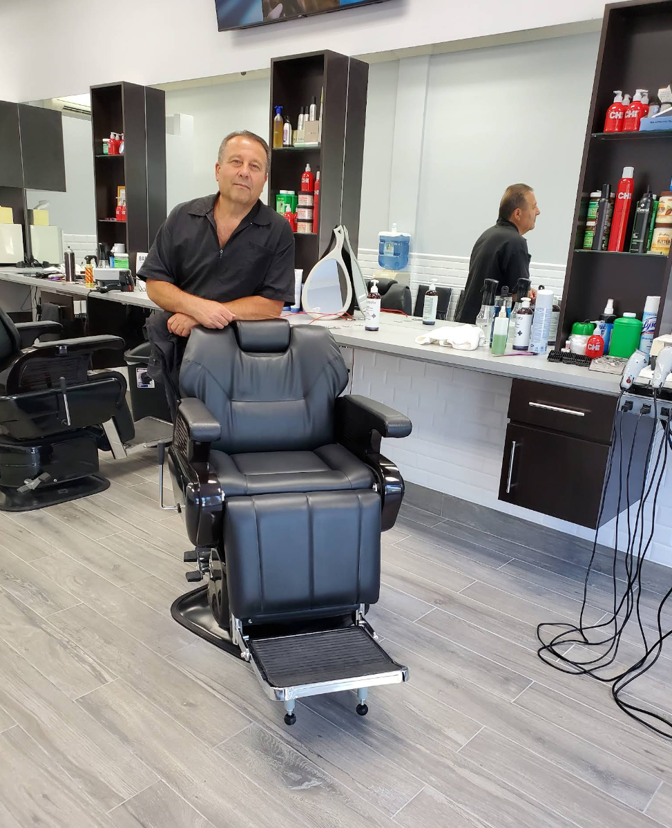 Yury standing behind a barber chair inside the shop